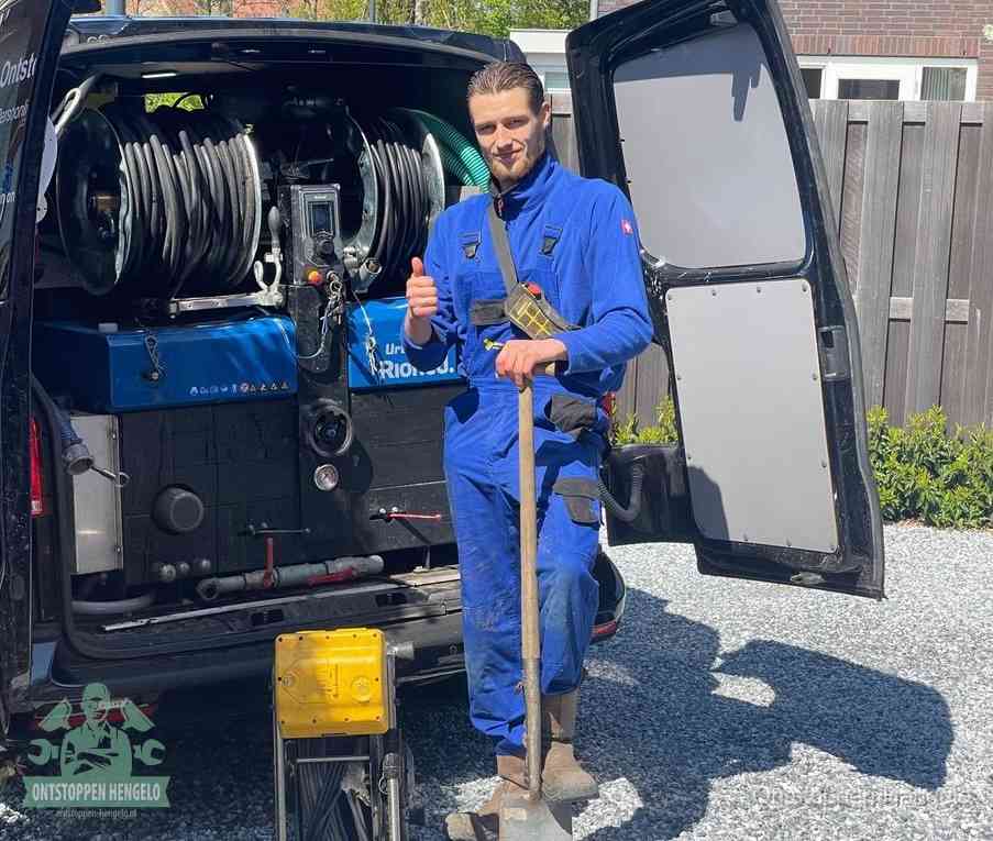 Een tevreden monteur met opgestoken duim naast de bestelbus, slim ingrijpen bespaart kosten bij een verstopte afvoer in Hengelo