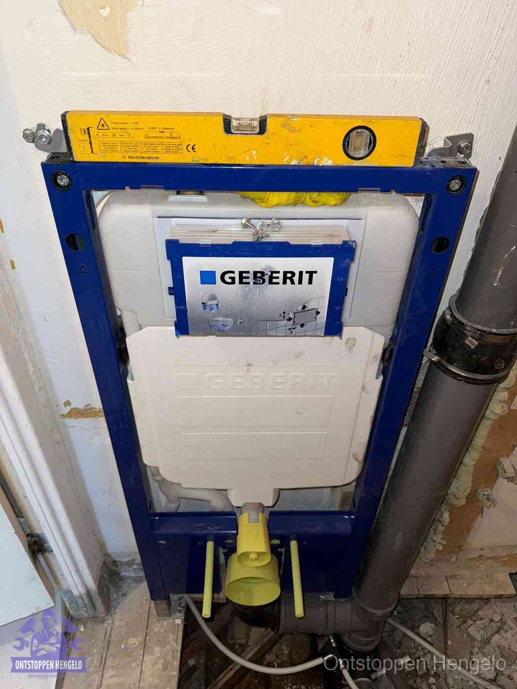 Een Geberit inbouwreservoir met frame voor een hangtoilet tegen de wand, met de afvoerbocht naar de vloer, kenmerkend voor een verstopt hangtoilet in Hengelo