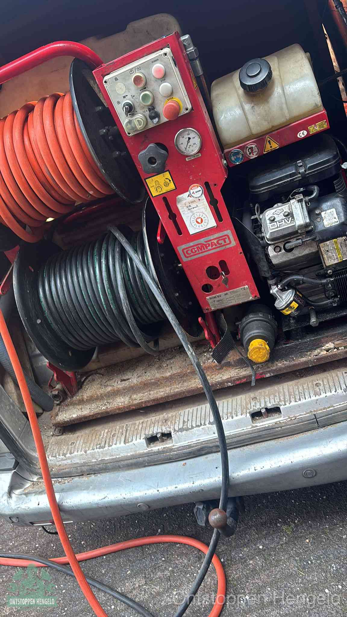 Een rood hogedruk-rioolreinigingstoestel in de laadbak van de bedrijfsbus, apparatuur voor een hardnekkige afvoerverstopping in Hengelo