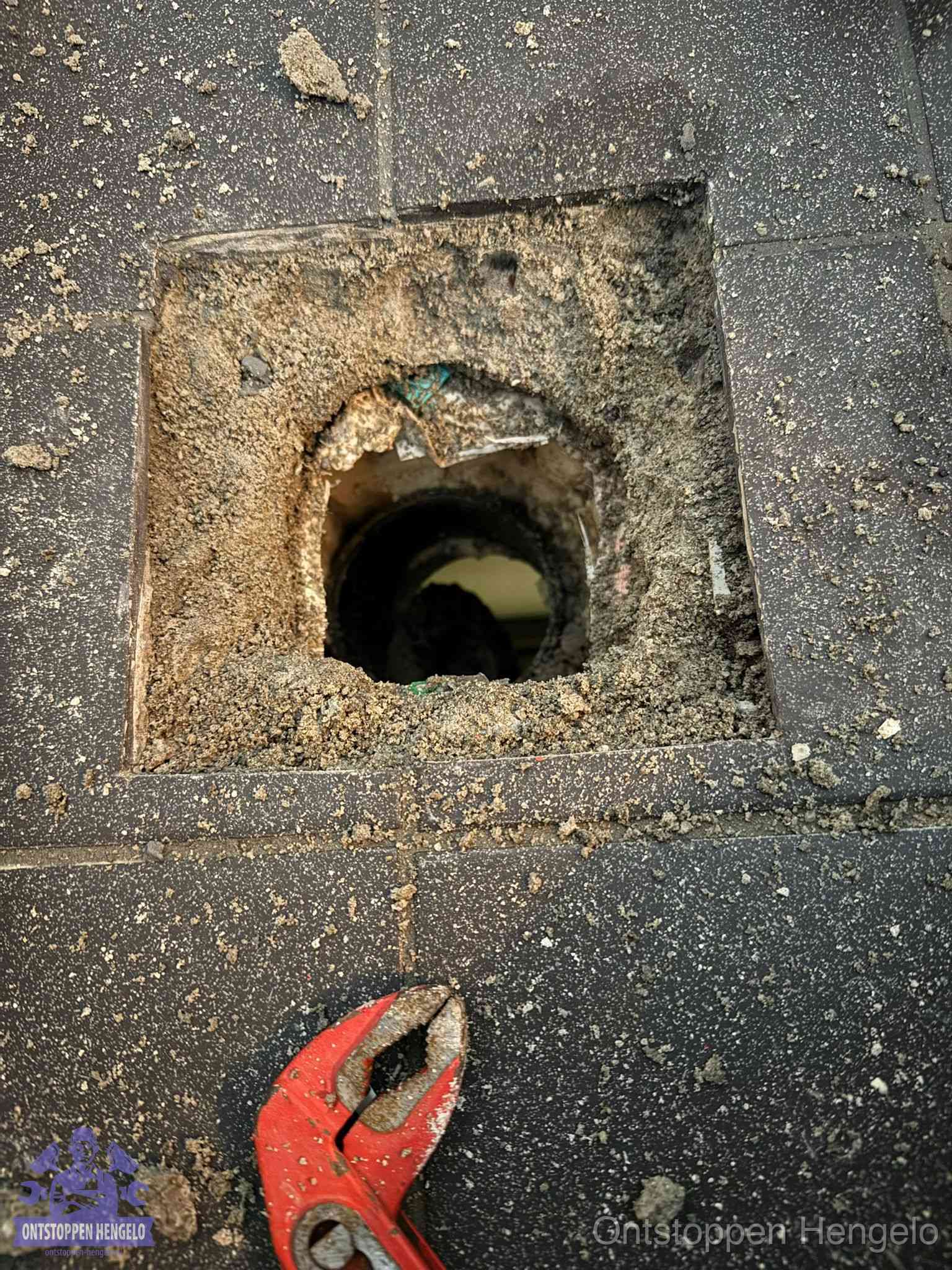 Geopend rioolputje op de erfgrens dat laat zien wie eigenaar is van de riolering in Hengelo