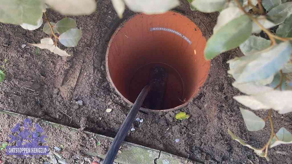 Open inspectieput in de tuin waar een veer rioolvliegjes en stankoverlast aanpakt in Hengelo
