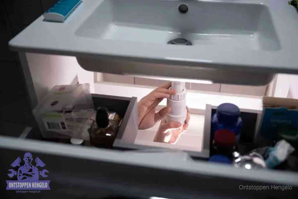 Een pompfles met zeep boven een wastafel in de toiletruimte, de warm water en afwasmiddel-methode om de wc te ontstoppen in Hengelo