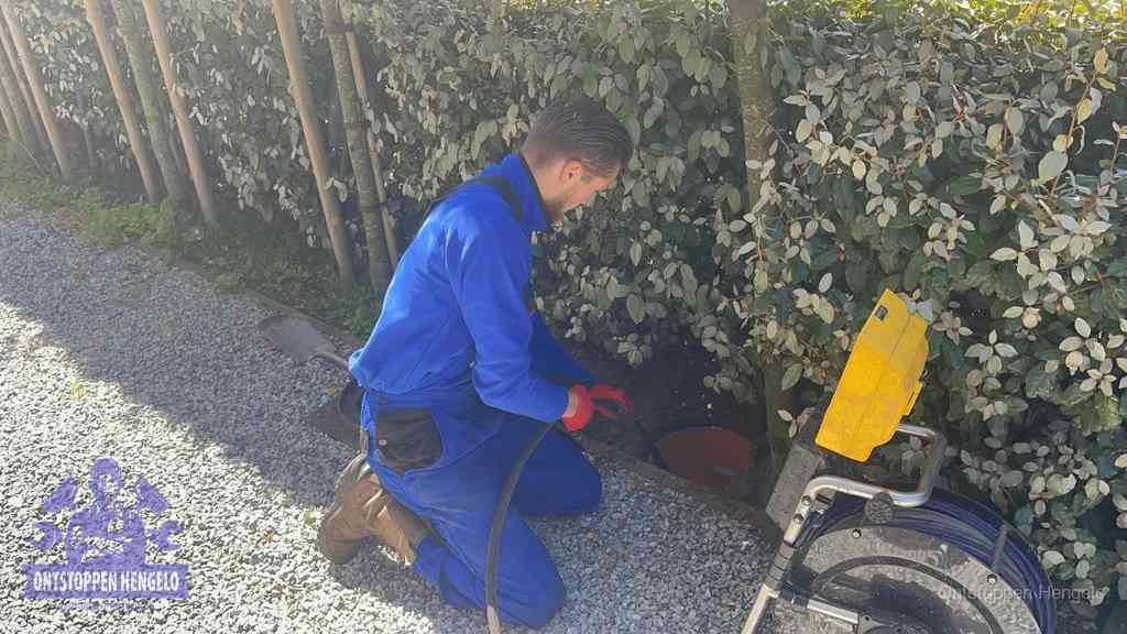 Monteur aan het werk bij een rioolput, de werkwijze voor riool ontstoppen in Hengelo