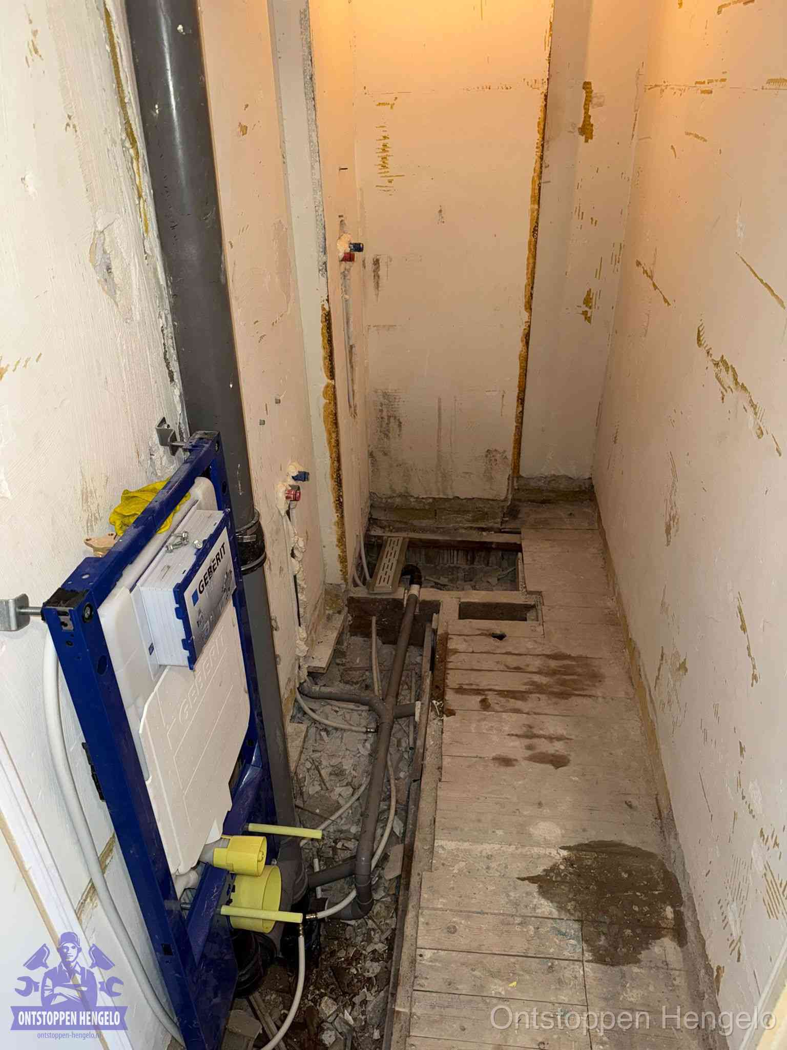 Een opgebroken toiletruimte tijdens renovatie met een Geberit inbouwreservoir en blootliggende oude afvoerleidingen, typisch voor oudere woningen in Hengelo